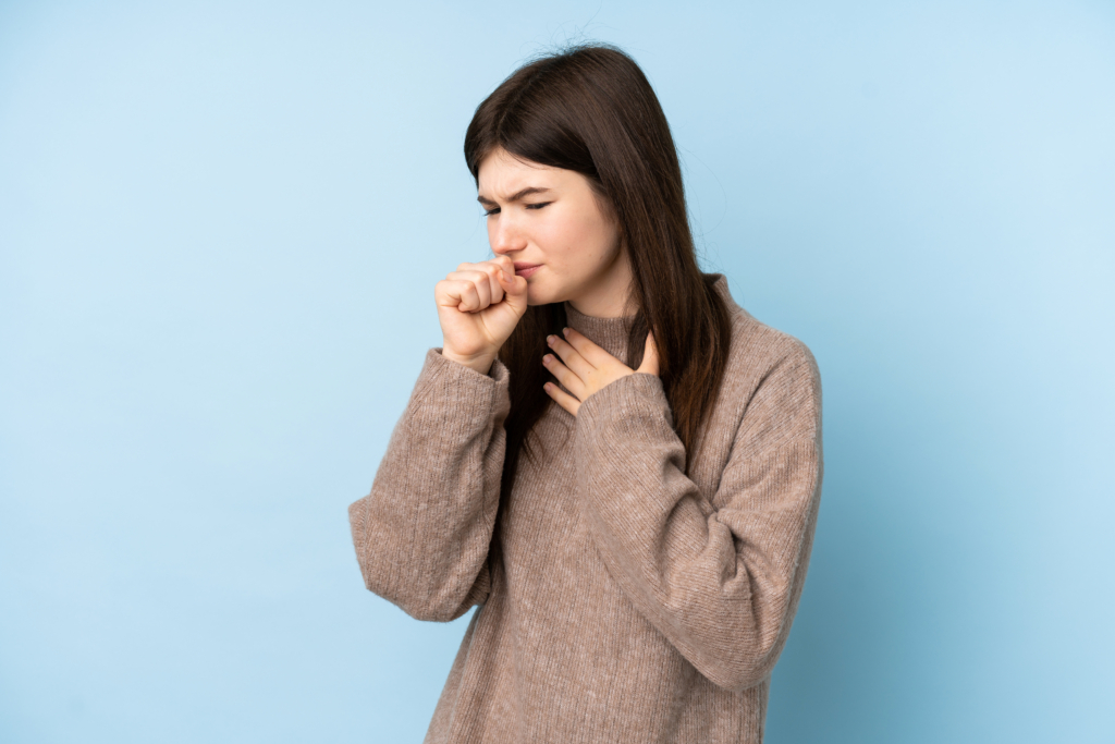 Young Ukrainian Teenager Girl Wearing A Sweater Over Isolated Blue Background Is Suffering With Cough And Feeling Bad