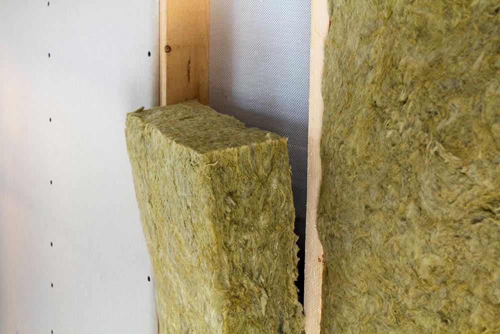 Close Up Of Wooden Frame For Future Walls Insulated With Rock Wool And Fiberglass Insulation Staff For Cold Barrier. Comfortable Warm Home, Economy, Construction And Renovation Concept.
